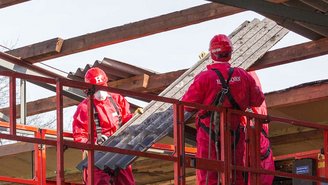 Fachkräfte auf Hebebühne bei der Sanierung eines Daches.