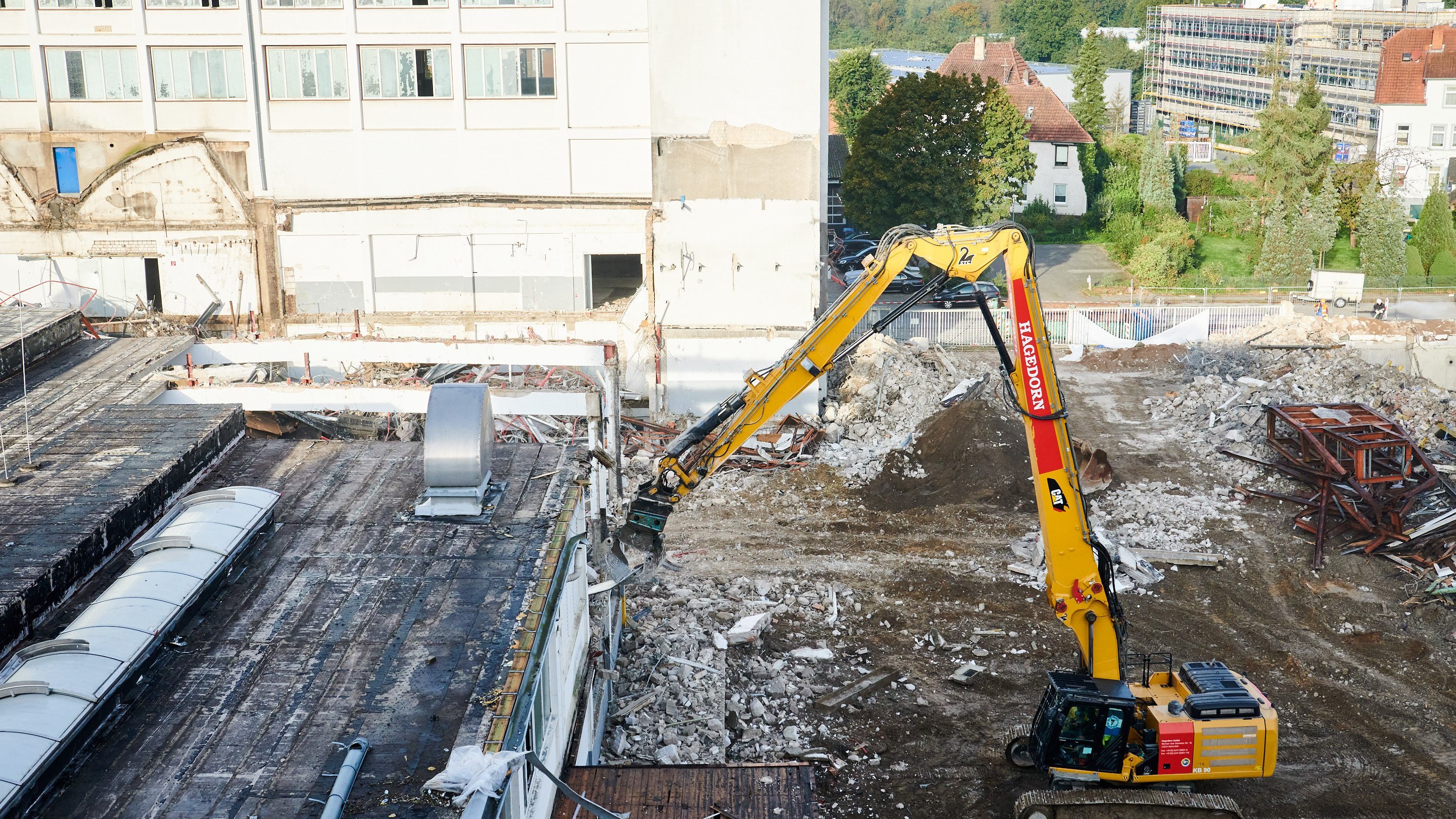 Abrissmaschine arbeitet an der Demontage eines alten, mehrstöckigen Gebäude.