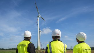 Team begutachtet Windkraftanlage, erneuerbare Energieprojekte.