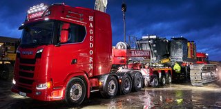 Schwertransport und Überführung eines Baggers in der Nacht