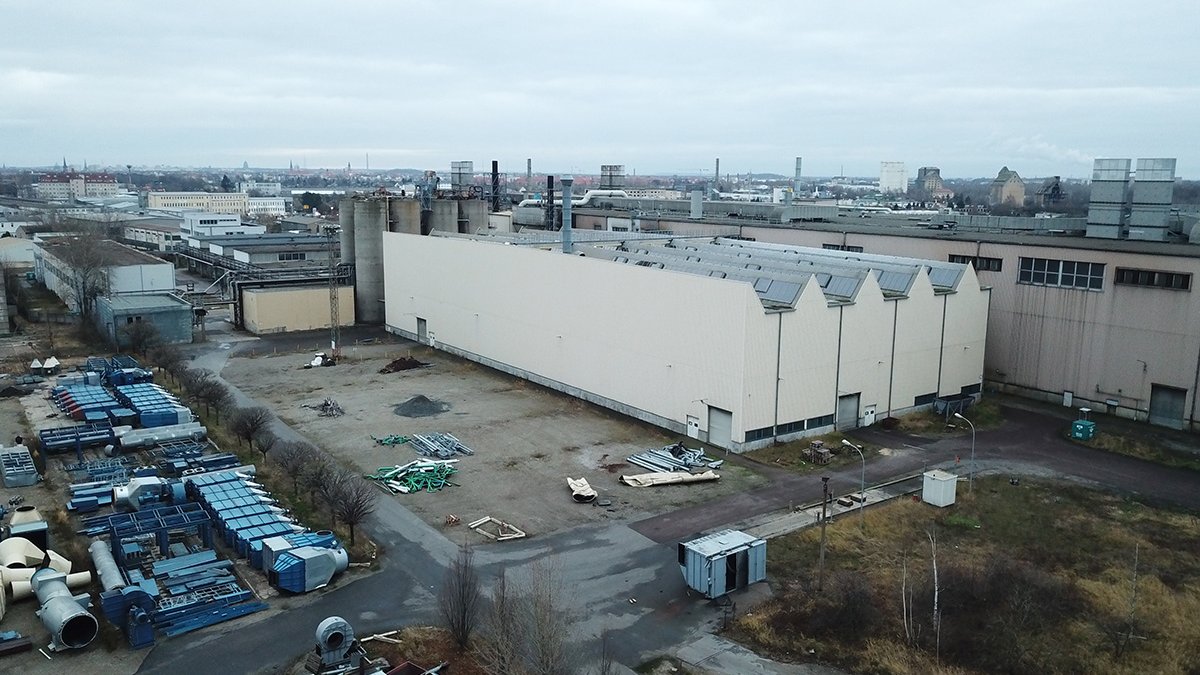 Industrieanlage mit Materiallagern und Fahrzeugen aus der Vogelperspektive