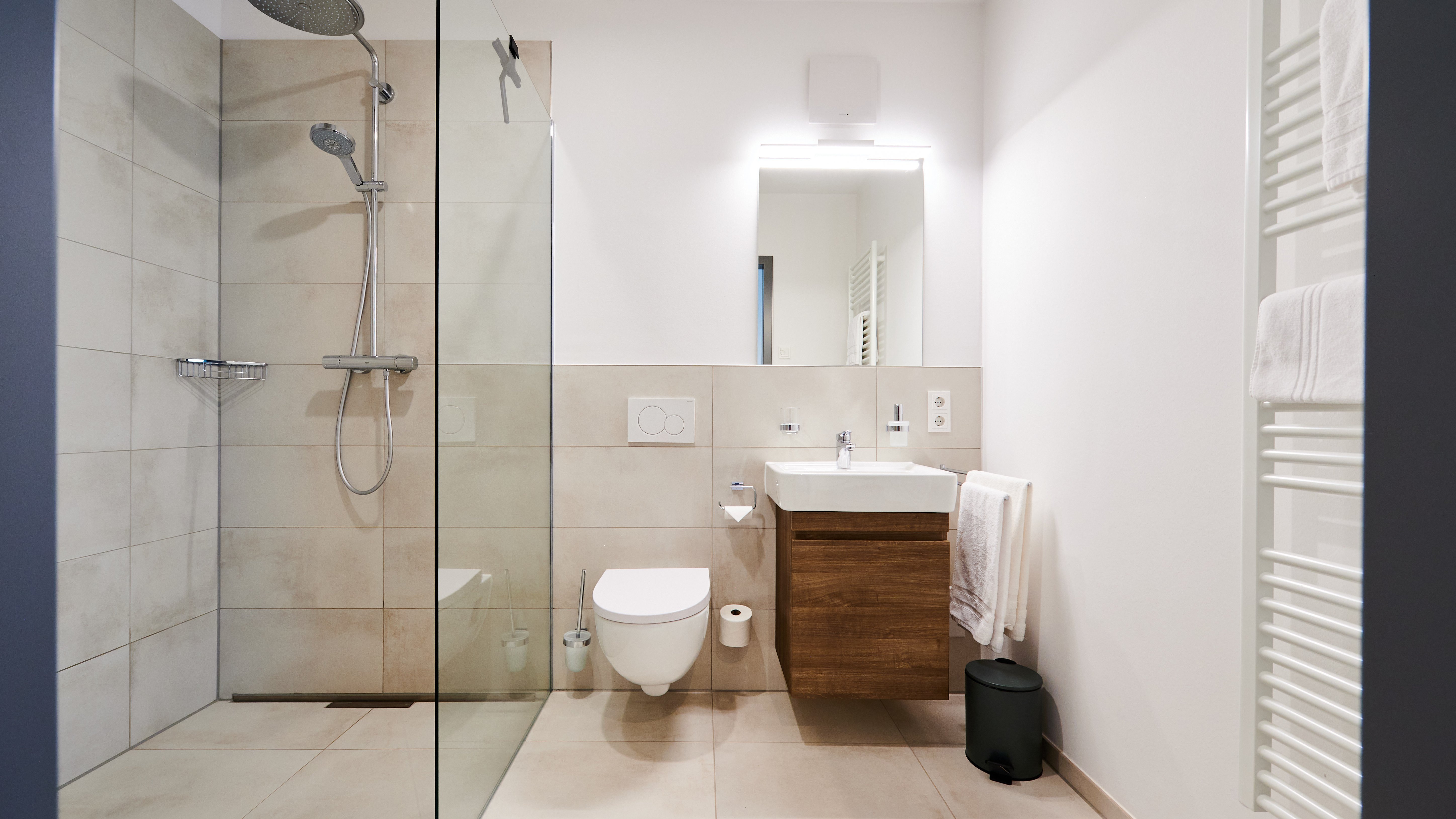 Helles Badezimmer mit begehbarer Dusche und modernen Armaturen