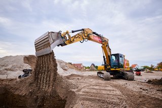 Gelber Bagger führt Tiefbauarbeiten auf einer Baustelle durch.