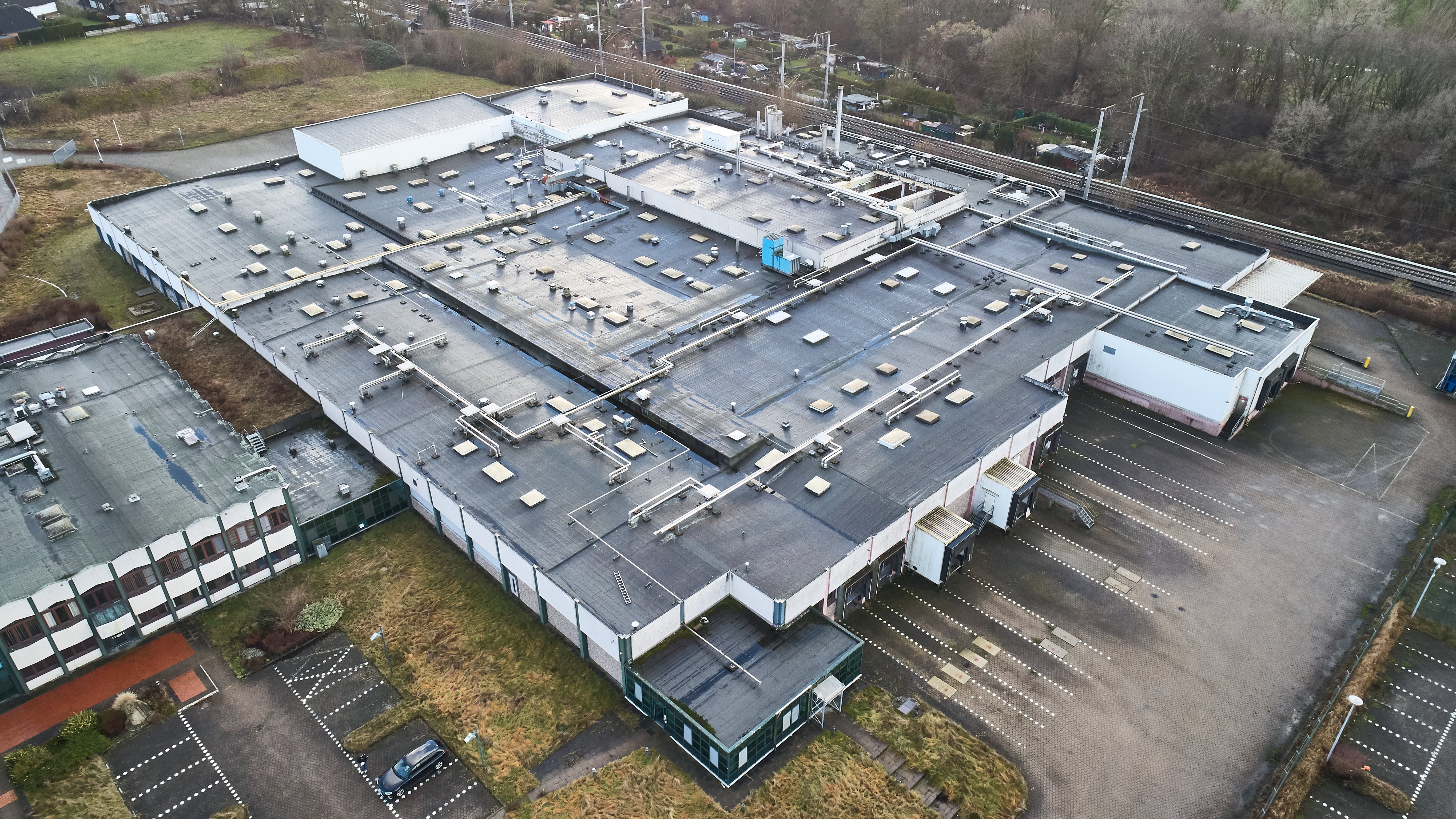 Industriekomplex neben Bahnlinie aus der Luft fotografiert
