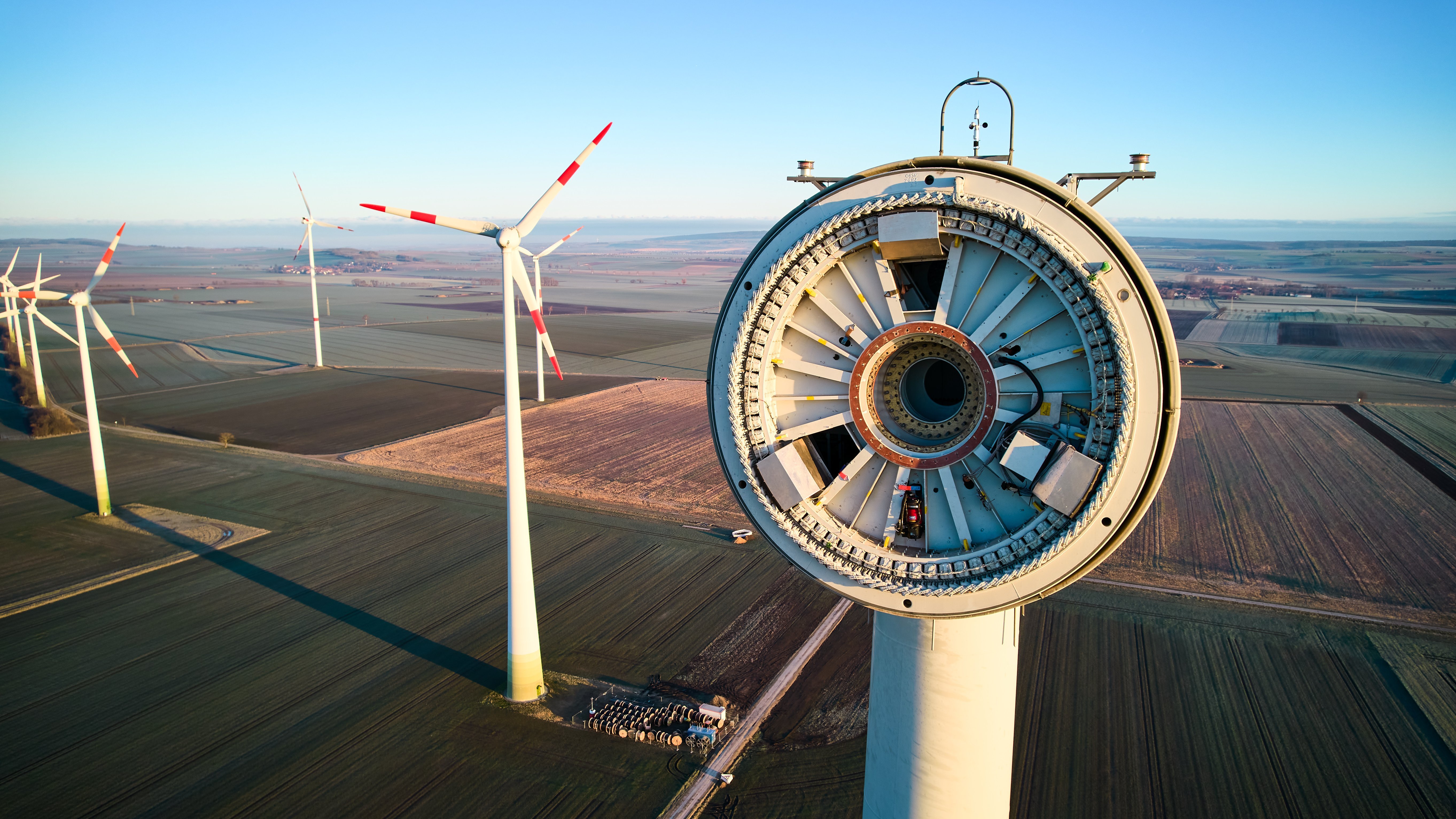 Blick in die Windradnabe mit Landschaft und Windrädern im Hintergrund.