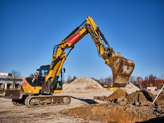 Gelber Bagger bei Erdarbeiten im Einsatz.