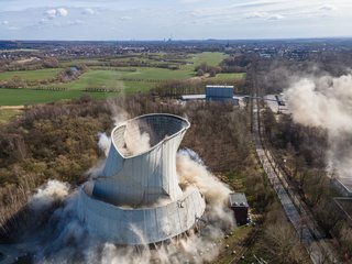 Kontrollierter Abriss eines Industriekühlturms durch Sprengtechnik.