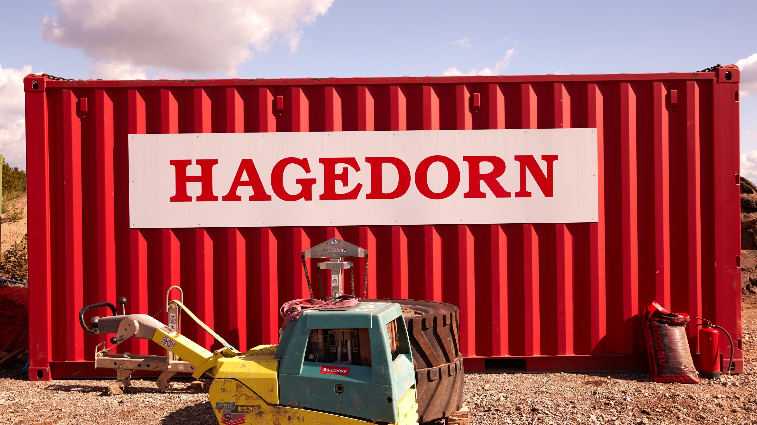 Roter Container mit Hagedorn-Logo in Baustellenbereich.