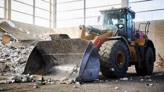 Großer Radlader transportiert Abbruchmaterial zur Entsorgung.