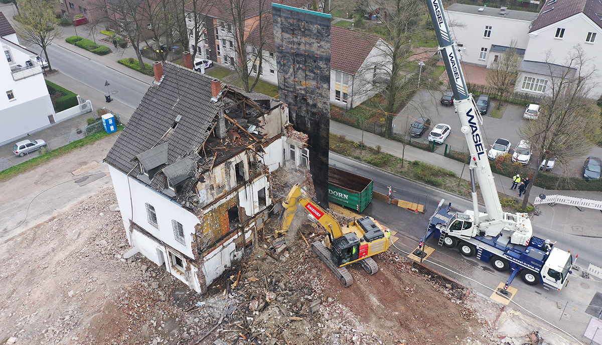 Bagger und Kran bei der Arbeit an einem Hausabbruch